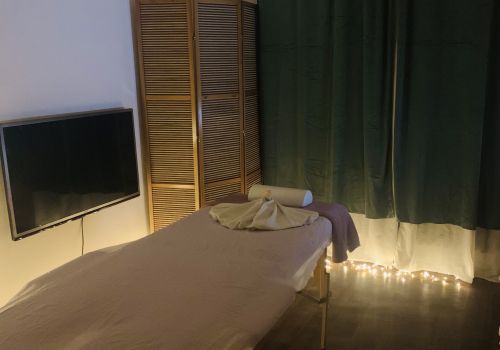 Marie Ančerlová sedí na masážním lehátku v bílém oblečení – domácí studio v Praze.